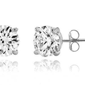 May include: A pair of silver stud earrings with round, clear cubic zirconia stones.