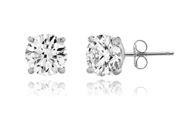 May include: A pair of silver stud earrings with round, clear cubic zirconia stones.