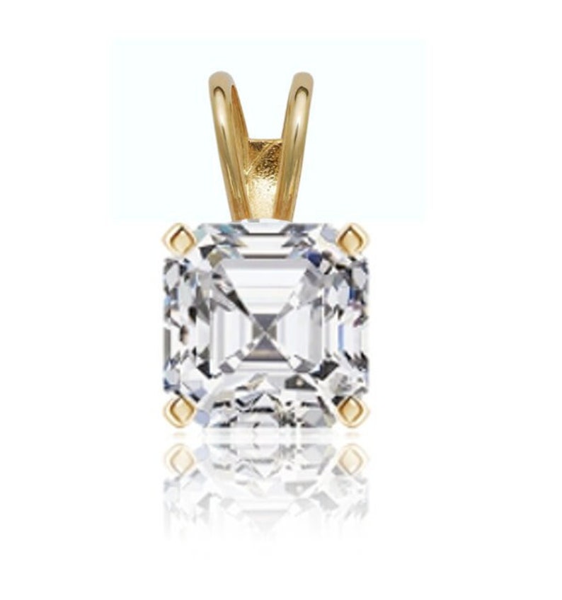 May include: A gold pendant featuring a clear, square-shaped, emerald-cut gemstone.