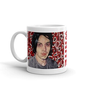 May include: White ceramic mug with a black and white photo of a person with black hair against a red and white geometric background. The text "WHITE" is printed vertically on the right side of the mug.