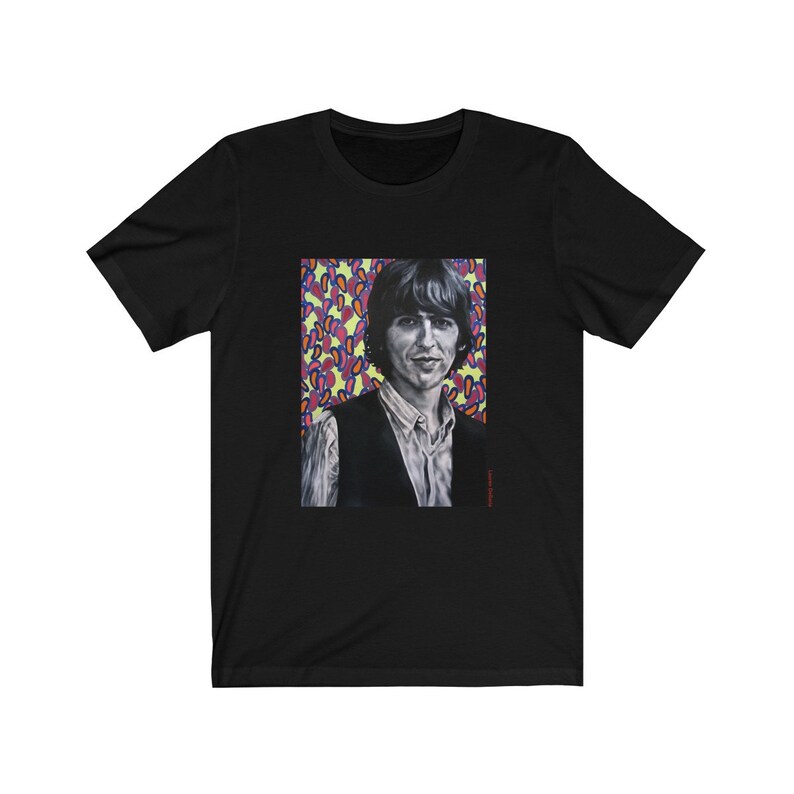 Puede incluir: Camiseta negra con un estampado gr&aacute;fico de un hombre con cabello oscuro y un chaleco negro sobre un fondo de formas abstractas de colores.