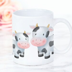 May include: White ceramic mug with a black and white cartoon illustration of two cows. The cows have black spots and pink noses.