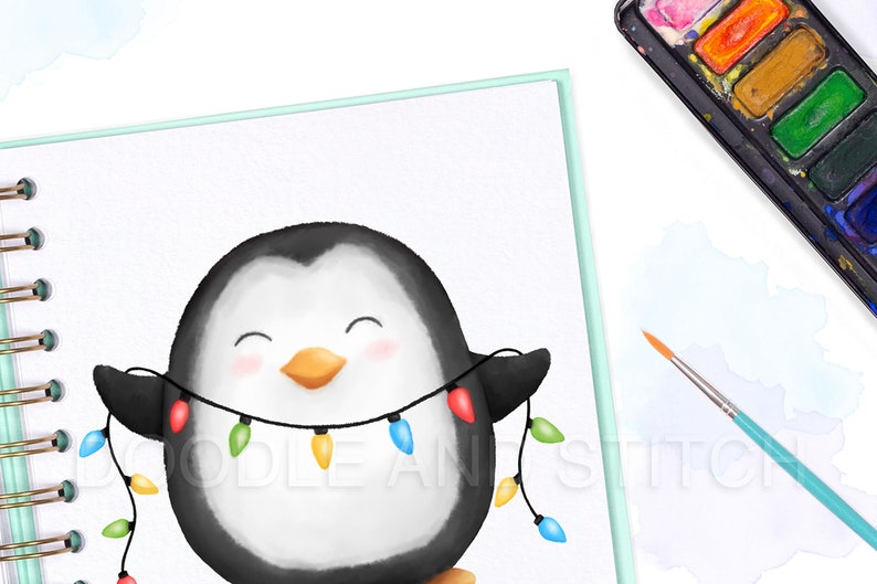 May include: A watercolor illustration of a penguin wearing a string of colorful Christmas lights. The penguin is smiling and has a happy expression. The illustration is drawn on a white page in a spiral bound notebook.