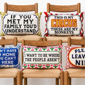 May include: Five rectangular needlepoint pillows with various text designs. The pillows feature phrases including 'If you met my family you'd understand', 'This is my circus these are my monkeys', 'You don't have to go home but you can't stay here', 'I want to be where the people aren't', and 'Please leave by nine'.