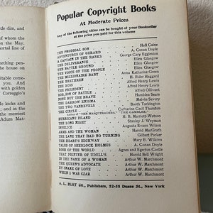 May include: Open book page with a list of titles from "Popular Copyright Books" at moderate prices. The titles and authors are listed in two columns. The book is open on a white surface.