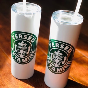 May include: Two white stainless steel tumblers with green lids and straws. Each tumbler has a green circle logo with the text "VERSED KETA MINE" and a stylized mermaid with a crown.