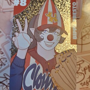 Peut inclure: Une carte &agrave; collectionner rectangulaire &agrave; finition holographique repr&eacute;sentant un personnage de clown illustr&eacute; portant une casquette ray&eacute;e avec une ic&ocirc;ne de ballon animal. Le personnage tient une balle de baseball et porte un gant, avec le texte #8 et BIPPY PRESTO visible.