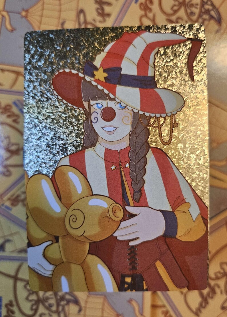 Peut inclure: Une carte &agrave; collectionner holographique rectangulaire repr&eacute;sentant un personnage d&eacute;guis&eacute; en clown avec un chapeau et une cape &agrave; rayures rouges et blanches. Le personnage a des cheveux tress&eacute;s, un nez rouge et tient un ballon en forme de chien.