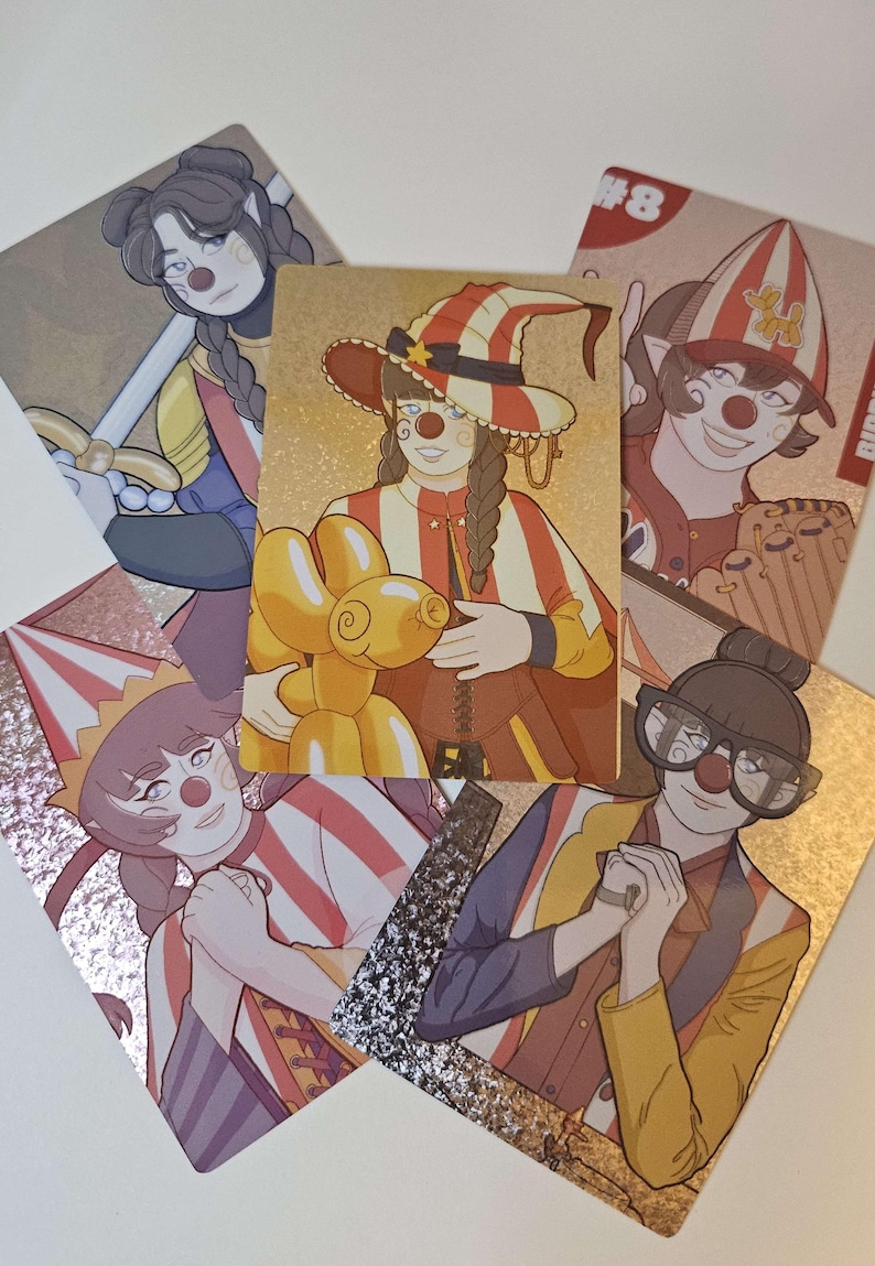 Peut inclure: Une collection de cinq cartes &agrave; collectionner rectangulaires illustrant des personnages au maquillage de clown, incluant des nez rouges. Les cartes pr&eacute;sentent diverses tenues, des chapeaux ray&eacute;s et un ballon animal jaune, avec des finitions m&eacute;tallis&eacute;es.