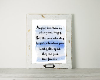 May include: A framed print with a blue watercolor background and a quote about true friends: "Anyone can show up when you're happy. But the ones who stay by your side when your heart falls apart, they are your true friends."