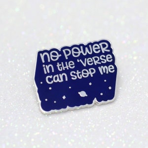 May include: A blue enamel pin with a white outline and the text "no power in the 'verse can stop me". The pin has a starry night background with a small planet.