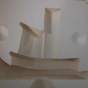 May include: A matte off-white ceramic mold shaped like a multi-level structure with a curved base, vertical pillars, and a flat roof section. The object features clean, smooth lines and a hollow interior, designed for casting clay or plaster forms.