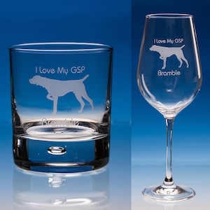 May include: Two clear glass items, a tumbler and a wine glass, with etched dog designs. Both feature a dog silhouette and the text "I Love My GSP" and "Bramble". The background is a blue gradient.