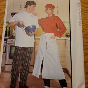 May include: A McCall's pattern envelope showing two people in chef's clothing. The man wears a white chef's coat, striped trousers, and a cap, holding a bowl and whisk. The woman wears a red top, white apron, and a beret. The text "McCall's" is at the top.