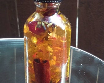 Puede incluir: Una botella de vidrio transparente con tapa negra llena de un líquido amarillo y varias flores secas y un palo de canela.