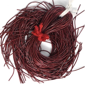 May include: A bundle of maroon leather cord, approximately 100 strands, tied together with a red yarn. The cord is thin and flexible, suitable for jewellery making or other crafts.