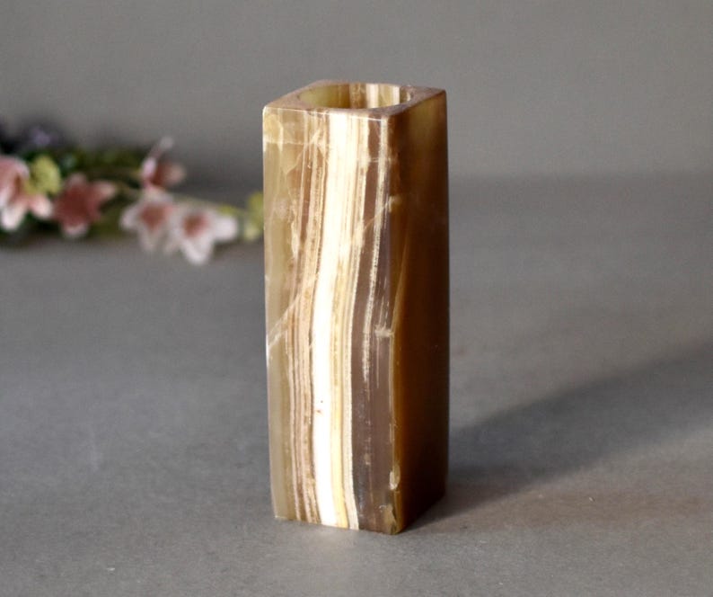 K&ouml;nnte beinhalten: Eine quadratische, braune und wei&szlig;e Onyx-Vase mit glatter, polierter Oberfl&auml;che.