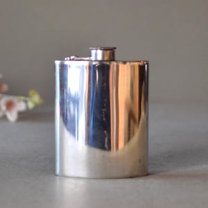 Peut inclure: Une gourde en argent de forme arrondie avec un couvercle à charnière.