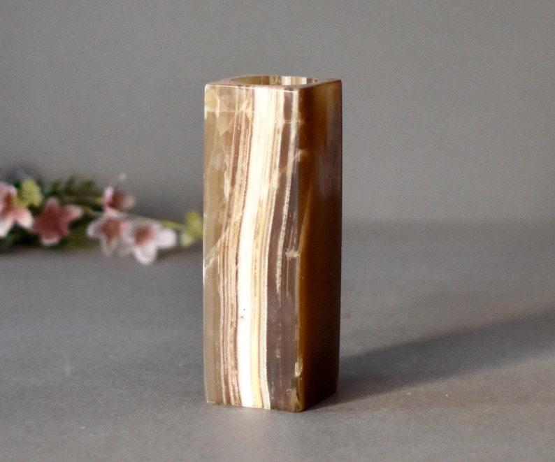 K&ouml;nnte beinhalten: Eine quadratische Onyx-Vase mit braunen und wei&szlig;en Streifen.
