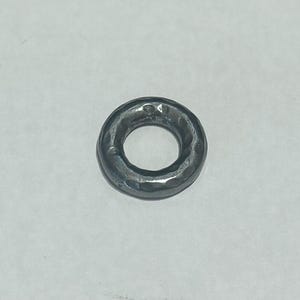 Puede incluir: Un anillo de metal plateado con textura martillada.