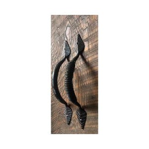 May include: Two black metal door handles with a leaf design and a spring-like detail.