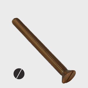 May include: A bronze-colored, slotted flat head machine screw. The screw has a threaded shaft and a flat head with a single slot for a screwdriver. The screw is designed for use in machinery and other applications.