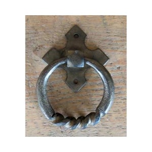 May include: A black metal door knocker with a twisted ring handle and a decorative cross-shaped backplate.