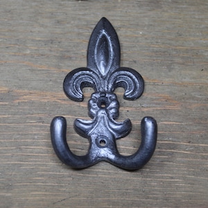 May include: Black metal double hook with a fleur-de-lis design.