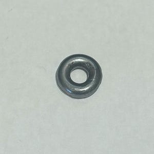 Puede incluir: Un anillo de metal plateado con un agujero redondo en el centro.