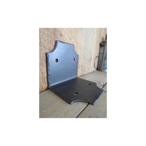 May include: A black metal corner brace with a decorative design and four holes for mounting. The brace is made of sturdy metal and is perfect for adding support to furniture or other projects.