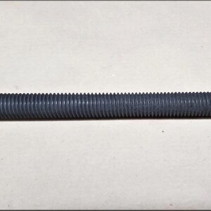May include: A black threaded rod, a type of metal fastener used in construction and manufacturing.