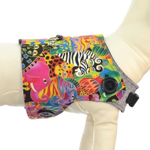 Puede incluir: Un chaleco para perro colorido con estampado de animales de la selva. El chaleco tiene una correa gris y un botón negro. Arnés vendido por separado.