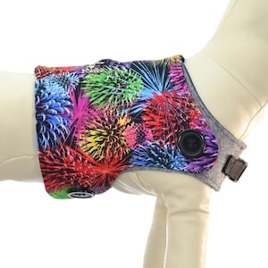 May include: A colorful dog harness cover with a firework pattern. The harness cover is made of a soft, comfortable fabric and features a button closure. Harness sold separately. It's a doggy thing Pawzly.com