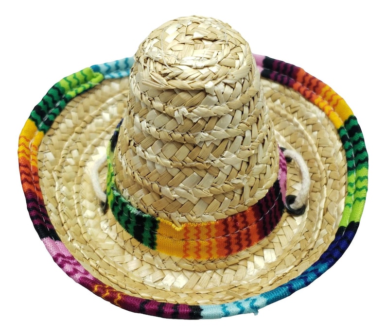 May include: A small straw sombrero with a colorful woven band. The band features a variety of colors, including pink, blue, green, yellow, orange, and red.