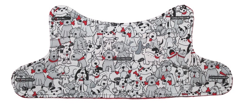 Puede incluir: Tela blanca con un patr&oacute;n de perros negros y grises que llevan collares rojos. La tela tiene la forma de un collar de perro.