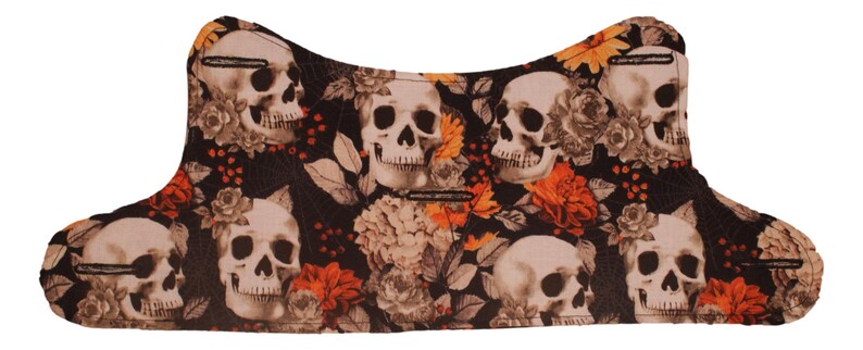 May include: Black fabric with a skull and floral pattern. The fabric features white skulls with black eyes and a black floral pattern with orange, yellow, and white flowers.