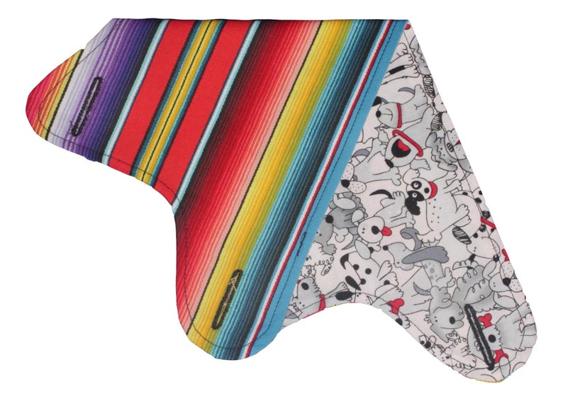 Puede incluir: Un pa&ntilde;uelo triangular con un patr&oacute;n de rayas coloridas en un lado y un lado blanco con un patr&oacute;n de perro blanco y negro. El pa&ntilde;uelo est&aacute; hecho de tela y tiene un borde cosido.