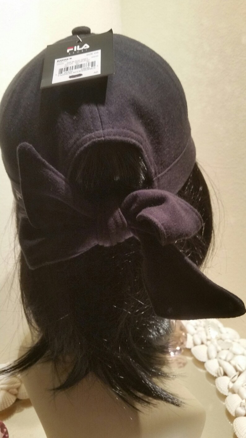 May include: Black baseball cap with a Fila Sport logo and a black fabric tie at the back.