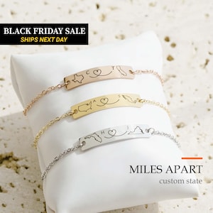 May include: Three metal chain bracelets with curved rectangular plates. The top plate is rose gold with a Texas and California map outline, the middle is gold with a USA and Mexico map, and the bottom is silver with Florida and Virginia maps.
