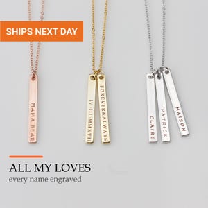 May include: Three delicate necklaces with vertical bar pendants in rose gold, gold, and silver tones. The rose gold bar is engraved with MAMA BEAR. The gold bars feature IV-III-MMXVII and FOREVER & ALWAYS. The silver bars are engraved with CLAIRE, PATRICK, and MAISON.