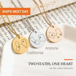 May include: Three circular pendant necklaces with thin metal chains. Each pendant features an engraved map of two US states connected by a dotted line with a small heart on each state. The text reads TWO STATES, ONE HEART for the miles between.