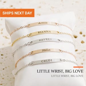 May include: Five delicate metal chain bracelets with horizontal rectangular bars, each engraved with a unique name: Alyssa, Rianna, Audrey, Stella, and Chloe. The bracelets feature varying metallic finishes including gold, silver, and rose gold tones.