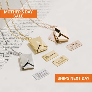 May include: Gold and silver envelope pendant necklaces with personalized tags. The tags have phrases like "Love you more" and "You're my sunshine." The image also includes the text "Mother's Day Sale."