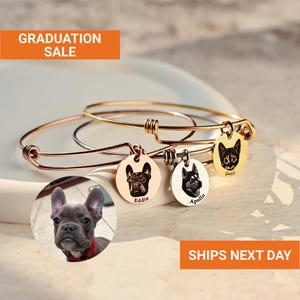 May include: Three metal charm bracelets with engraved pet portraits. Each bracelet has a different metal finish: rose gold, silver, and gold. The charms feature dog and cat faces with names. The image includes the text "GRADUATION SALE".