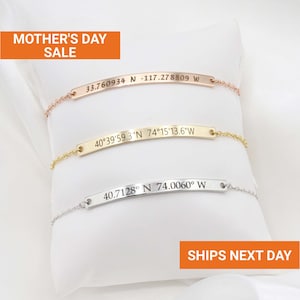 May include: Three personalized bar bracelets in rose gold, gold, and silver, each with engraved coordinates. The bracelets are displayed on a white pillow. The text "MOTHER'S DAY SALE" is visible.