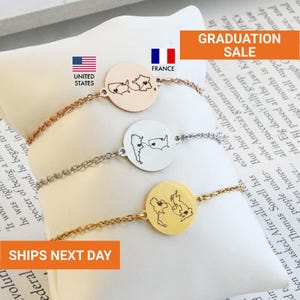 May include: Three delicate bracelets with circular pendants, each featuring a map outline and a heart. The bracelets are in rose gold, silver, and gold tones. The image includes the text "GRADUATION SALE".