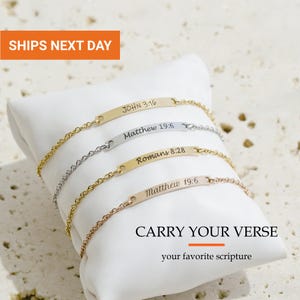 May include: Four metal chain bracelets with flat rectangular bars engraved with scripture references: JOHN 3:16, Matthew 19:6, Romans 8:28, and Matthew 19:6. The bracelets are in gold, silver, and rose gold tones, featuring the text CARRY YOUR VERSE.