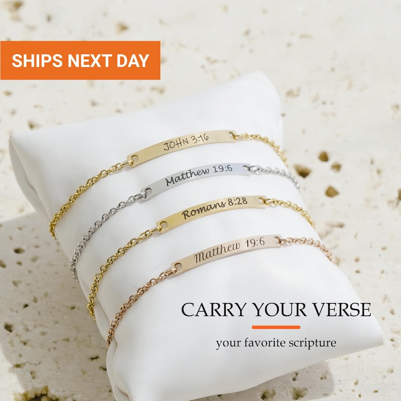 May include: Four metal chain bracelets with flat rectangular bars engraved with scripture references: JOHN 3:16, Matthew 19:6, Romans 8:28, and Matthew 19:6. The bracelets are in gold, silver, and rose gold tones, featuring the text CARRY YOUR VERSE.