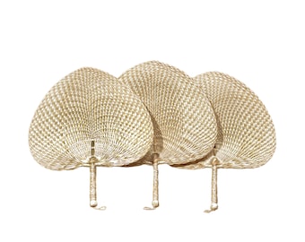 May include: Three woven, light brown, hand fans with white accents. The fans are folded and have wooden handles.