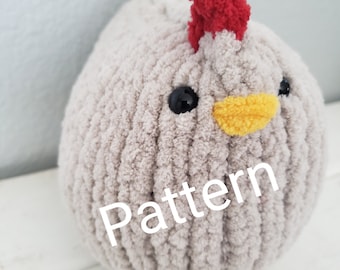 May include: A grey crocheted chicken plush toy with a red comb, black eyes, and a yellow beak. The toy is sitting on a white surface and the word "Pattern" is written on the toy.